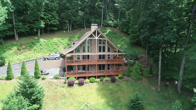 rear view of house with a deck, a yard, and a garage