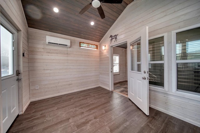 unfurnished sunroom featuring ceiling fan, a wall mounted AC, lofted ceiling, and a wealth of natural light