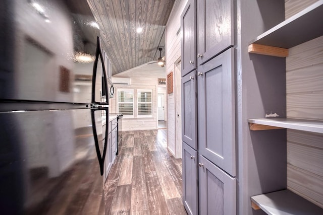 walk in closet featuring wood-type flooring, lofted ceiling, and an AC wall unit