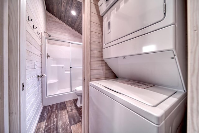 laundry room featuring stacked washer and dryer and dark wood-type flooring