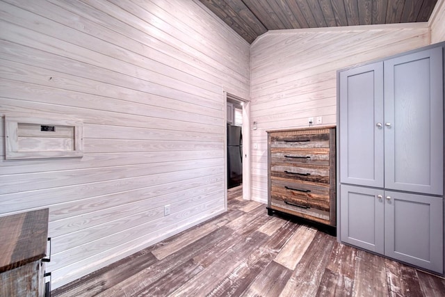 unfurnished bedroom with hardwood / wood-style flooring, wood walls, vaulted ceiling, and wooden ceiling