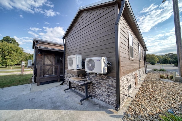 view of side of home with a patio and ac unit