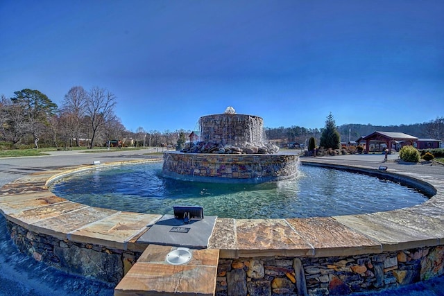 view of swimming pool with pool water feature and exterior kitchen