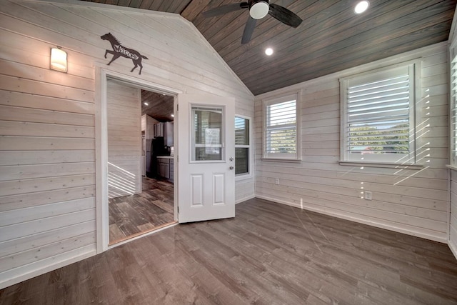 unfurnished bedroom featuring lofted ceiling and wood walls