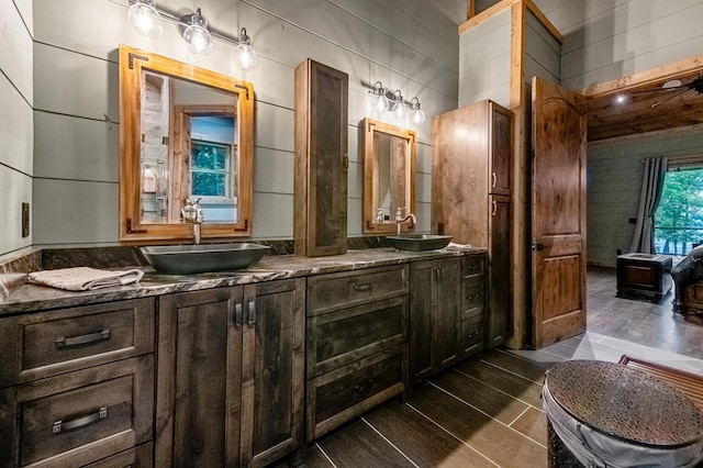 bathroom with vanity and wooden walls