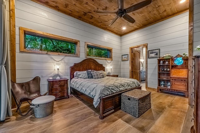 bedroom with ceiling fan, wooden ceiling, wood walls, and light wood-type flooring