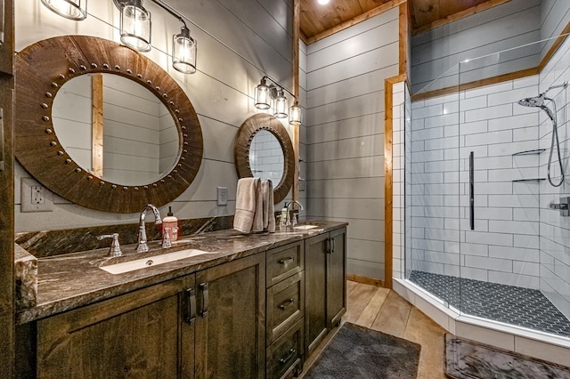 bathroom featuring vanity, an enclosed shower, and wooden walls