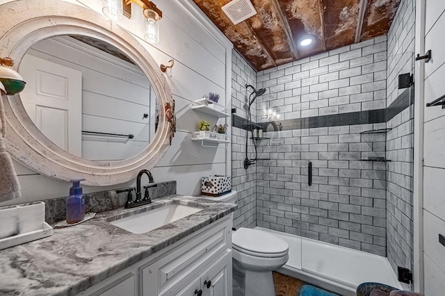 bathroom with vanity, toilet, and a shower with door