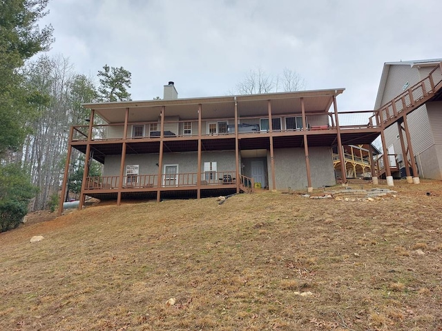 rear view of property featuring a chimney and a wooden deck