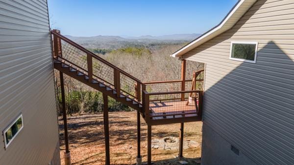 wooden terrace featuring stairway and a mountain view