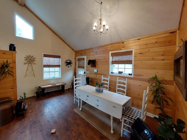 dining space featuring a chandelier, high vaulted ceiling, wood finished floors, and wooden walls