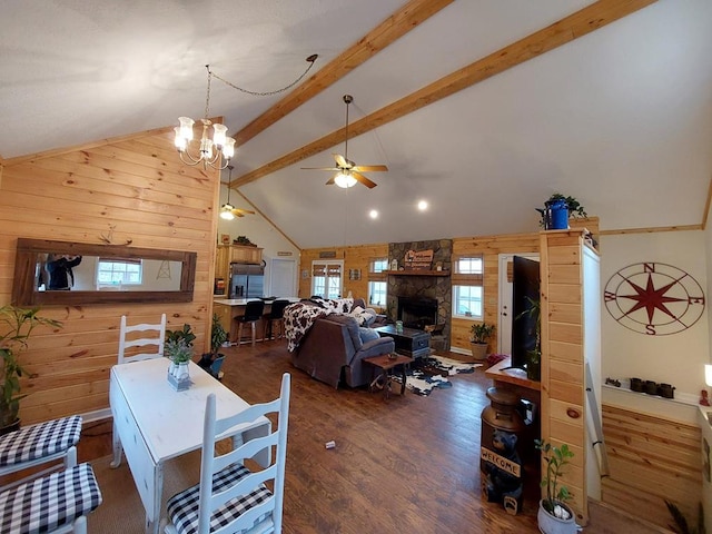 interior space with high vaulted ceiling, wooden walls, a fireplace, wood finished floors, and beamed ceiling