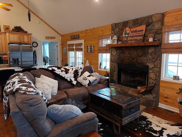 living room featuring wooden walls, visible vents, a fireplace, and wood finished floors