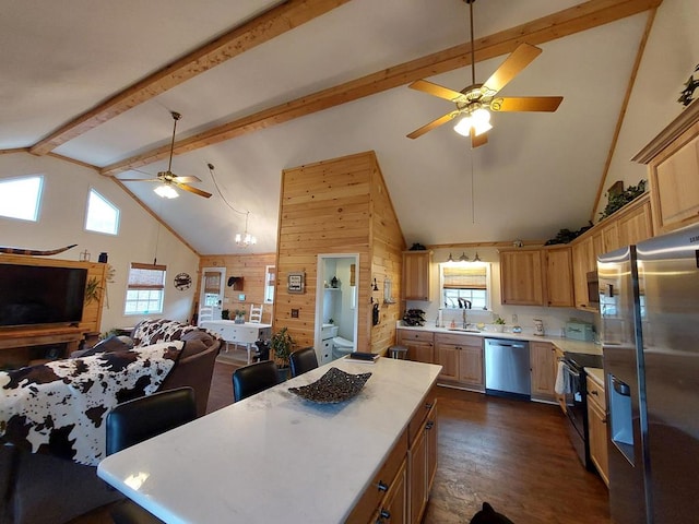 kitchen featuring wooden walls, stainless steel appliances, dark wood-type flooring, open floor plan, and light countertops