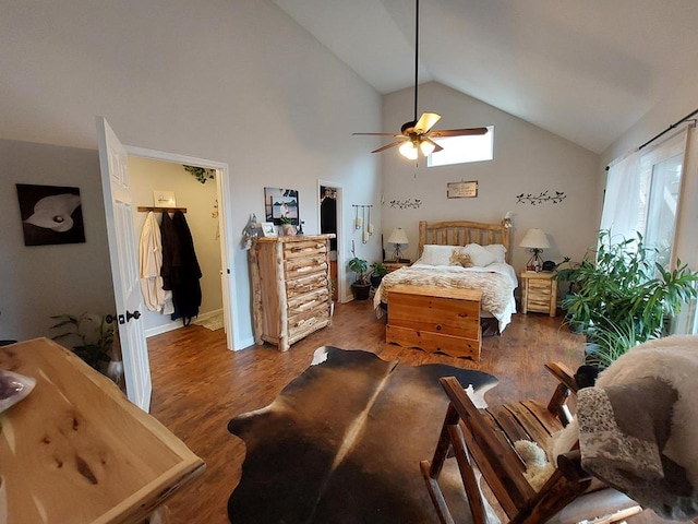 bedroom featuring a spacious closet, a ceiling fan, wood finished floors, high vaulted ceiling, and baseboards