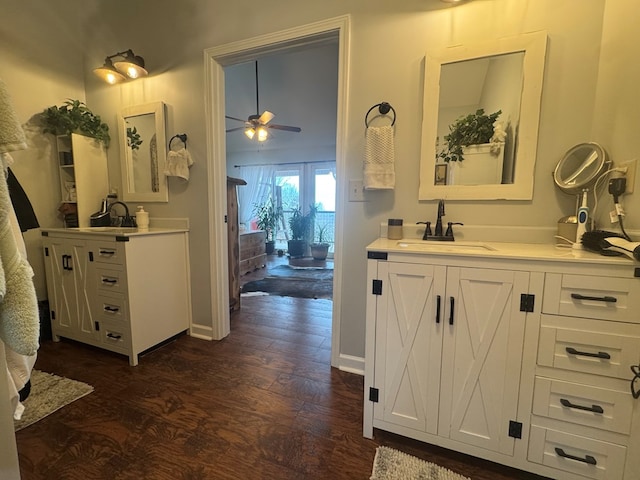 bathroom with a ceiling fan, two vanities, a sink, and wood finished floors