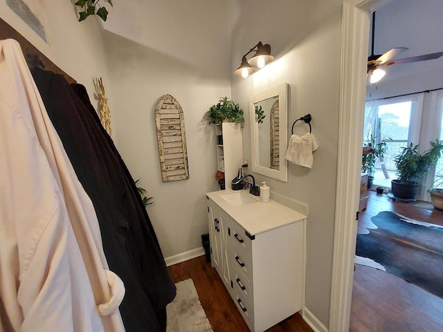 bathroom featuring a ceiling fan, vanity, baseboards, and wood finished floors