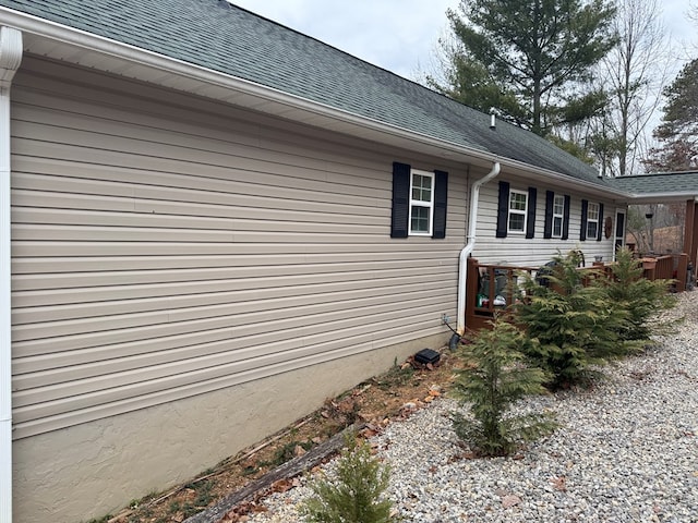 view of side of property with a shingled roof