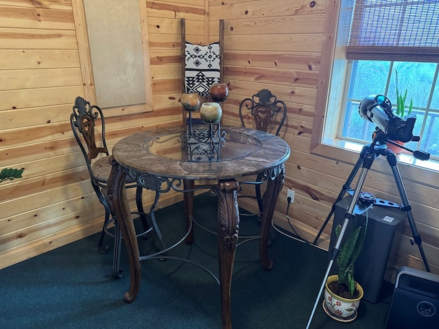 carpeted dining area with wooden walls