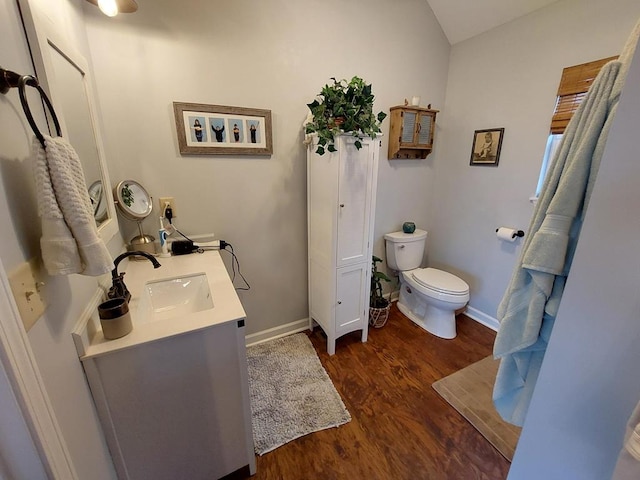 bathroom with vanity, wood finished floors, toilet, and baseboards