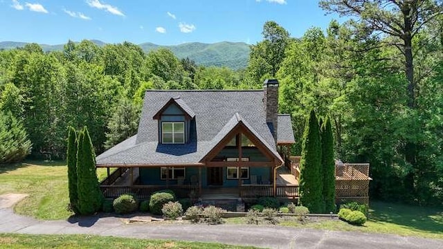 602 Mill Ridge Rd, Hiawassee, GA 30546 - view of front of property featuring a chimney, a porch, a mountain view, a view of trees, and a front lawn