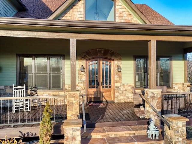 view of exterior entry featuring a porch and french doors