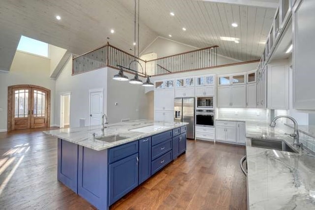 kitchen with sink, white cabinets, a large island, stainless steel appliances, and french doors