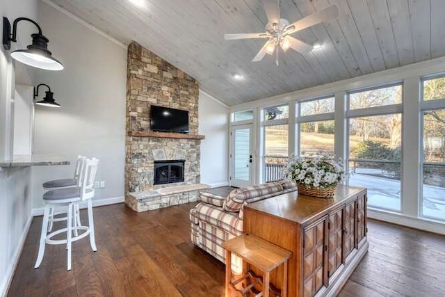 living room with a stone fireplace, vaulted ceiling, wooden ceiling, plenty of natural light, and dark hardwood / wood-style flooring