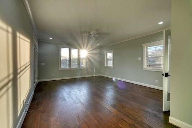 unfurnished room featuring dark hardwood / wood-style flooring, ornamental molding, and ceiling fan