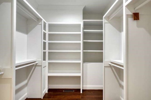 spacious closet with dark hardwood / wood-style flooring