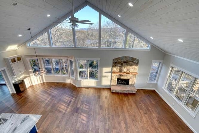 unfurnished living room featuring wood ceiling, dark hardwood / wood-style floors, a fireplace, and high vaulted ceiling