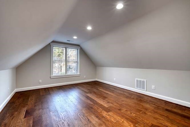 additional living space featuring vaulted ceiling and dark hardwood / wood-style flooring