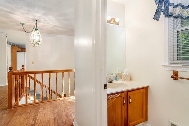 bathroom with a textured ceiling, vanity, and hardwood / wood-style flooring