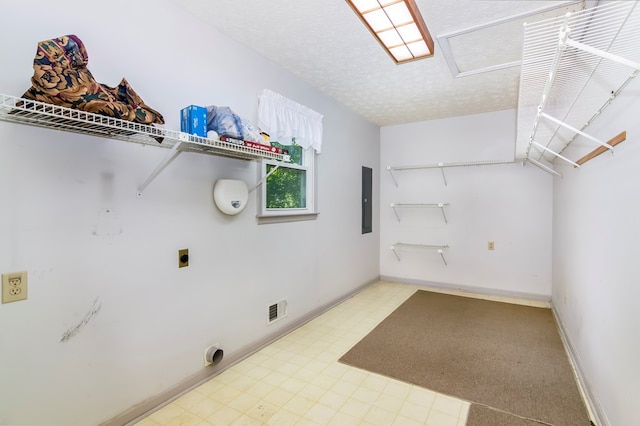 washroom featuring electric panel, hookup for an electric dryer, and a textured ceiling