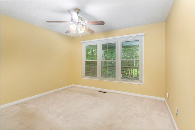 unfurnished room featuring a textured ceiling, ceiling fan, and carpet floors