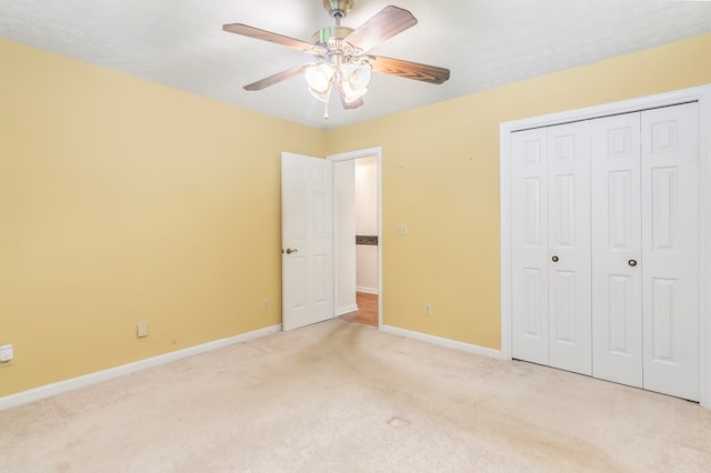 unfurnished bedroom featuring a closet, ceiling fan, light colored carpet, and a textured ceiling