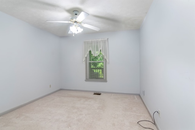 carpeted empty room with a textured ceiling and ceiling fan