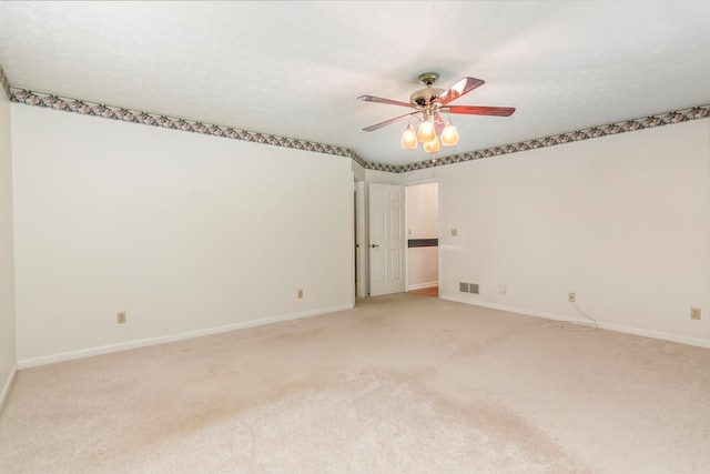 carpeted empty room with a textured ceiling and ceiling fan