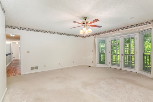 carpeted spare room featuring ceiling fan and a textured ceiling