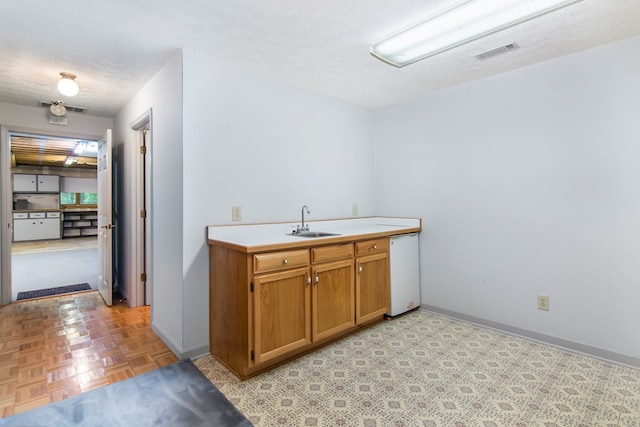 bathroom featuring a textured ceiling, vanity, and parquet floors