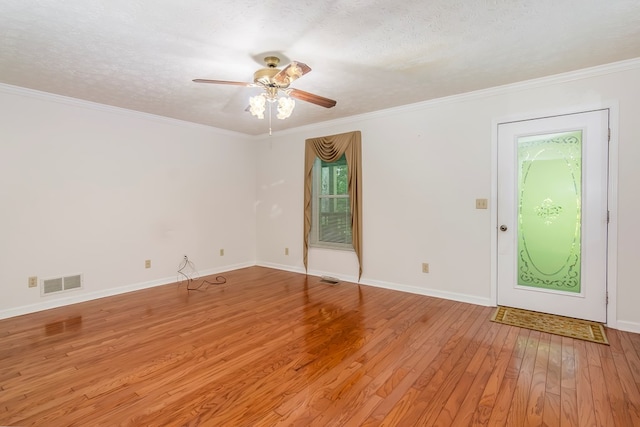 interior space featuring ceiling fan, ornamental molding, a textured ceiling, and light hardwood / wood-style flooring