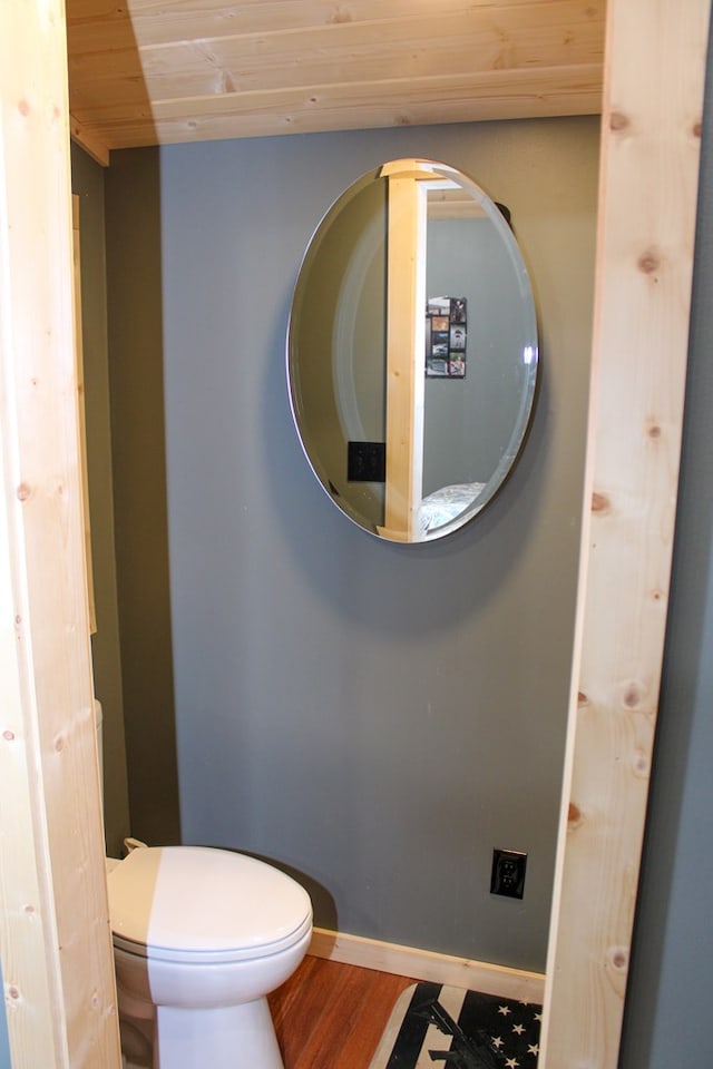 bathroom with wood ceiling, baseboards, toilet, and wood finished floors