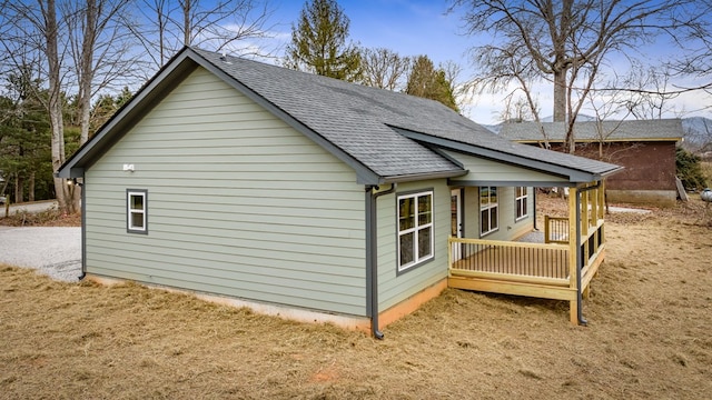 view of side of property with a porch and a yard