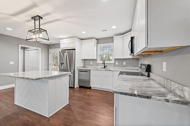 kitchen featuring sink, white cabinetry, a kitchen island, pendant lighting, and stainless steel appliances