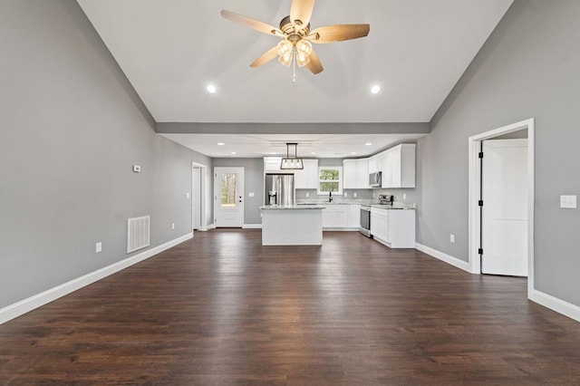 unfurnished living room featuring dark wood-type flooring, ceiling fan, lofted ceiling, and sink