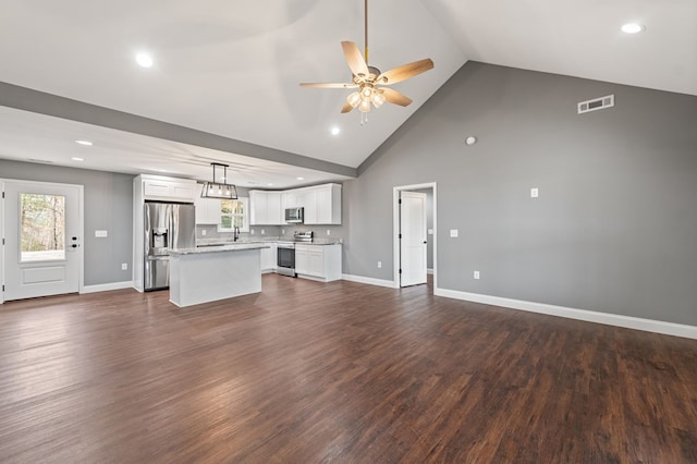 unfurnished living room featuring high vaulted ceiling, dark hardwood / wood-style floors, and ceiling fan