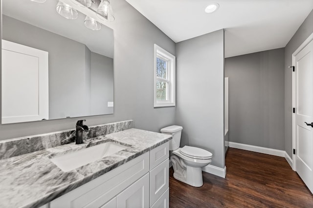 bathroom with vanity, toilet, and hardwood / wood-style floors