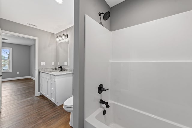 full bathroom featuring hardwood / wood-style flooring, shower / bathtub combination, vanity, and toilet