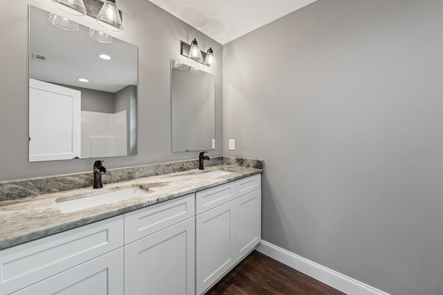 bathroom featuring vanity, wood-type flooring, and walk in shower