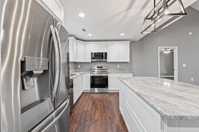 kitchen featuring stainless steel appliances, dark hardwood / wood-style floors, light stone counters, white cabinets, and decorative light fixtures